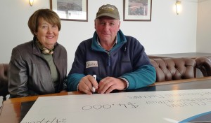 Robert Duncan signs the cheque for $4,000 - adding to the $2,000 already raised_media